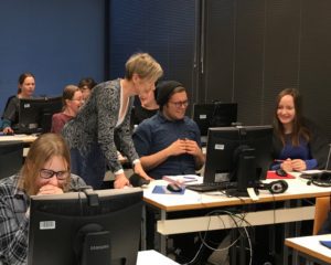 Group of people looking at computer screens and discussing together.